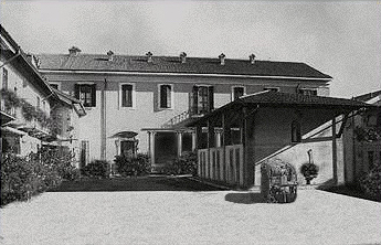 A black and white photo of Corte della Pesa, showing houses around a courtyard